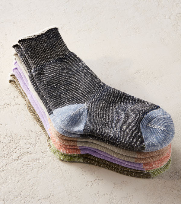 A stack of cozy Brooklinen socks in muted colors